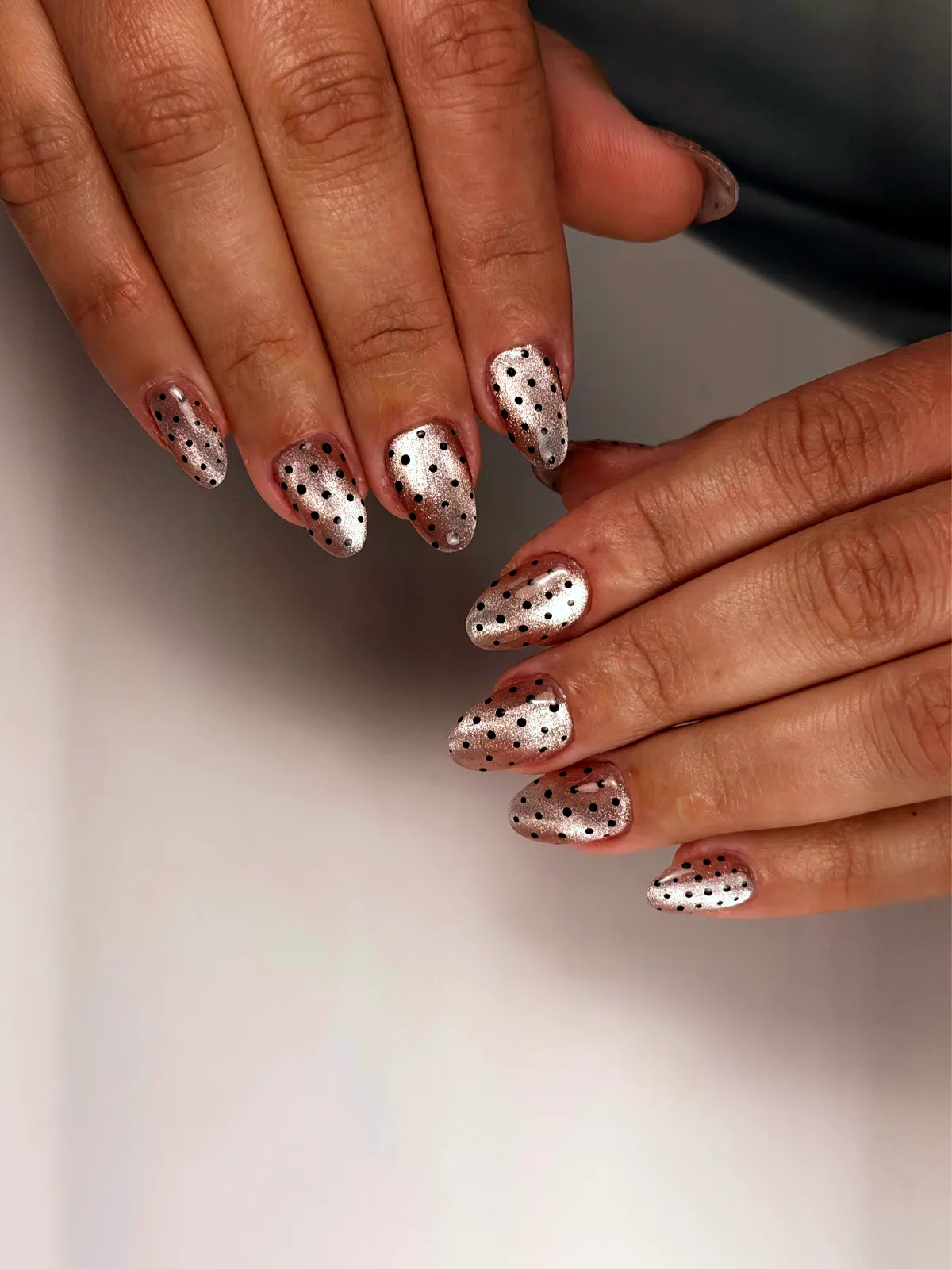 Almond nails in champagne metallic with black polka dots, by BeautyFusionClau in Sarasota, Florida