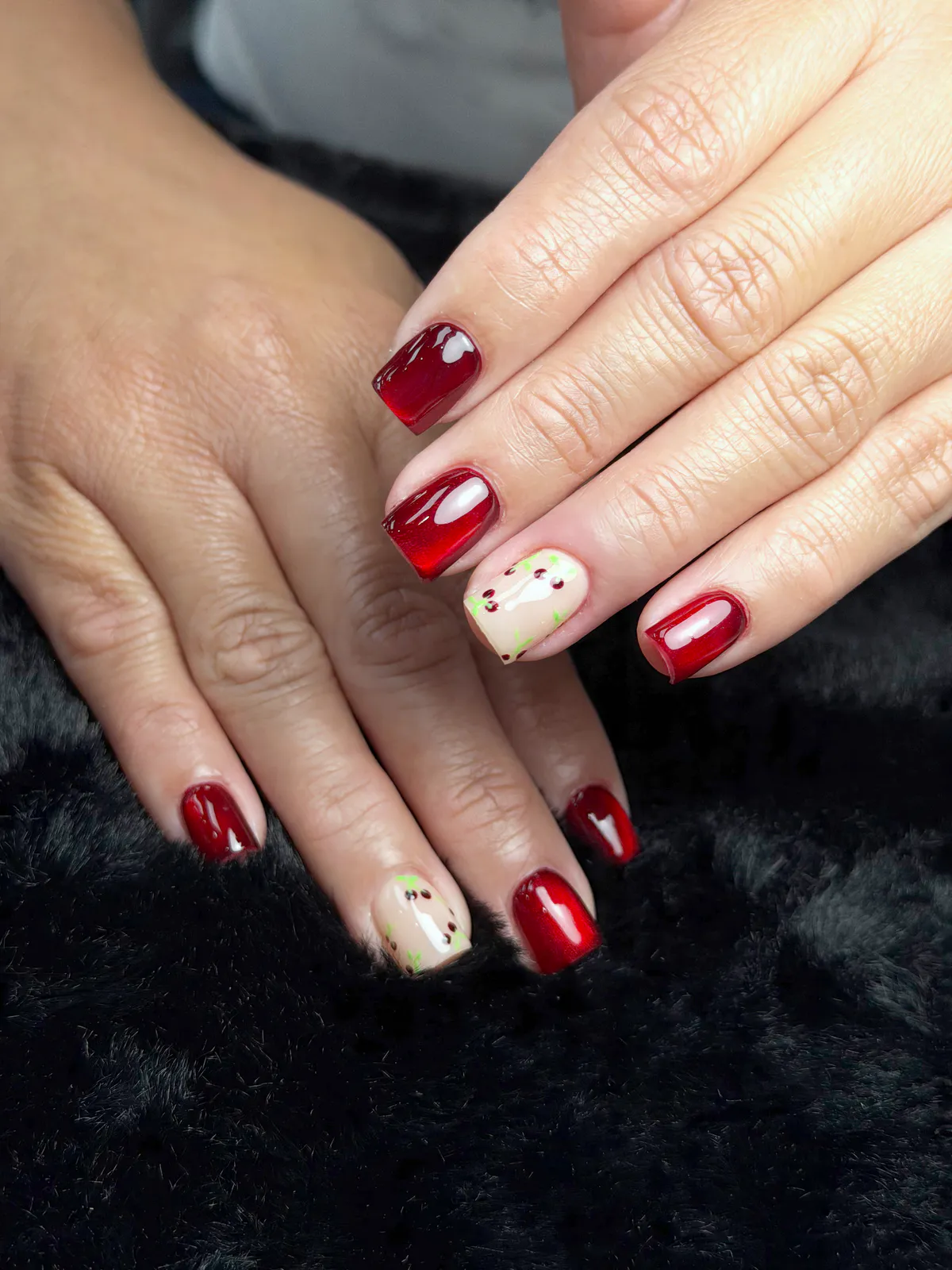 Short square deep-red jelly nails with nude accents and green and red dots, by BeautyFusionClau in Sarasota, Florida